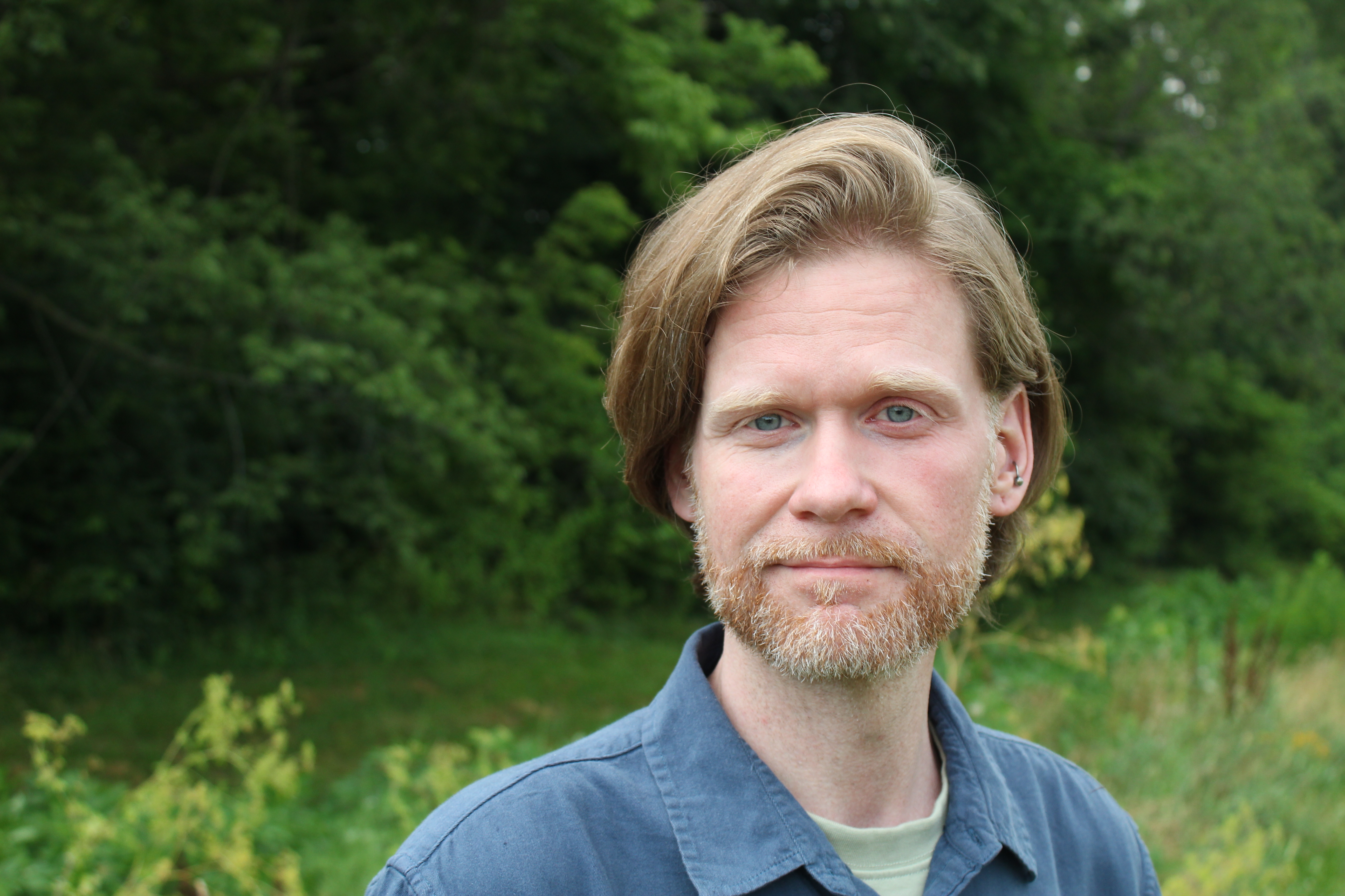 Josh Stanley, LCSW. Man stands in a field, looking into the camera.