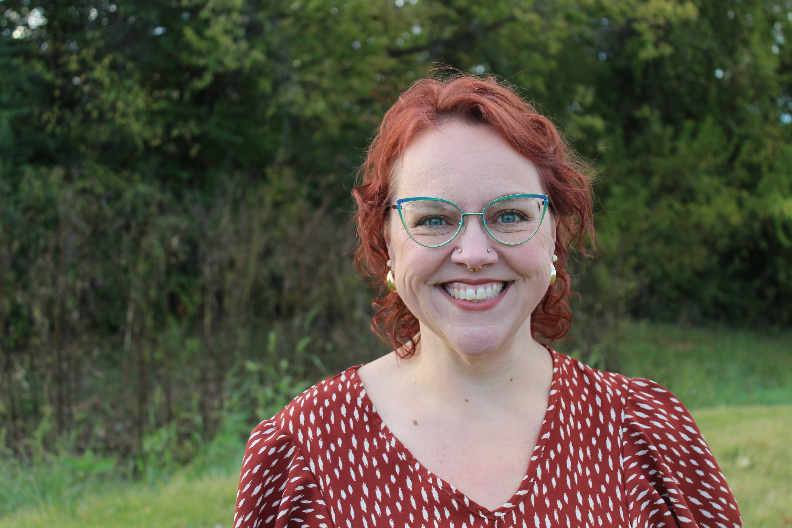 Christy Roeseler, MSW Student. Woman stands in a field, looking into the camera.